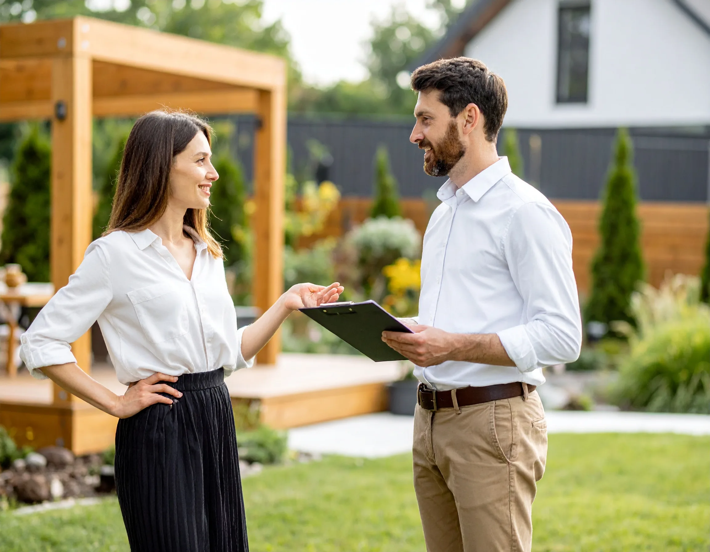 Contractor reviewing a completed outdoor project with a homeowner outside a modern home