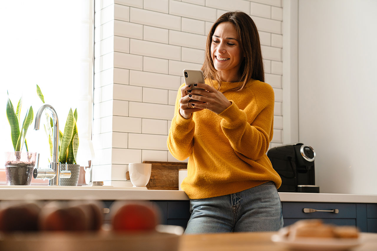Homeowner engaging on her phone in the kitchen